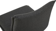 Detailaufnahme eines dunkelgrauen, stoffbezogenen Polsterstuhls mit geschwungener Rückenlehne, schräg von hinten/seitlich fotografiert.