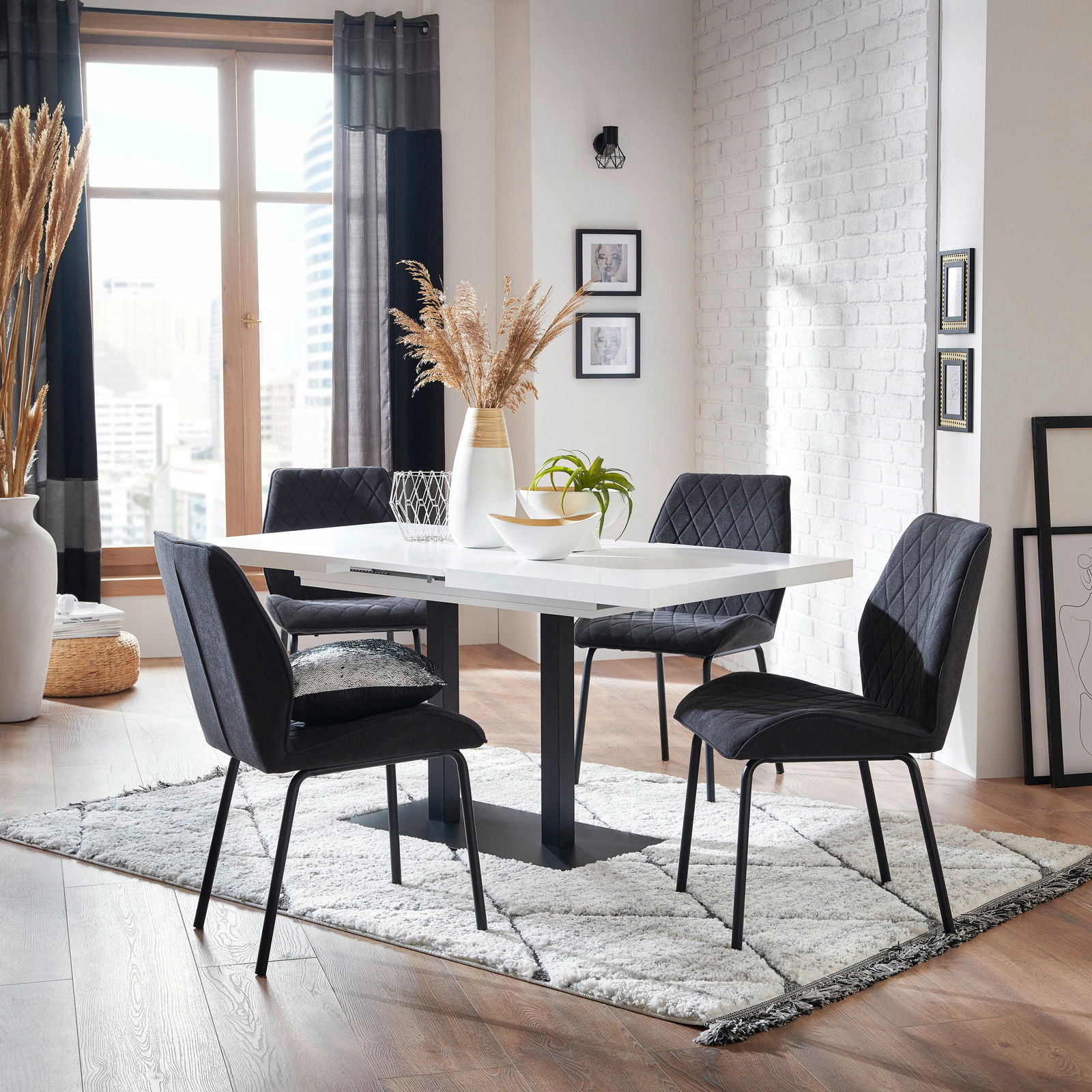 Z2 Funktions-Esstisch QUADRATO Moderner Esstisch mit schwarzem Gestell und weißer Tischplatte, umgeben von vier schwarzen Stühlen, in einem stilvoll eingerichteten Raum mit Holzboden und großen Fenstern. Perspektive: seitliche Ansicht.