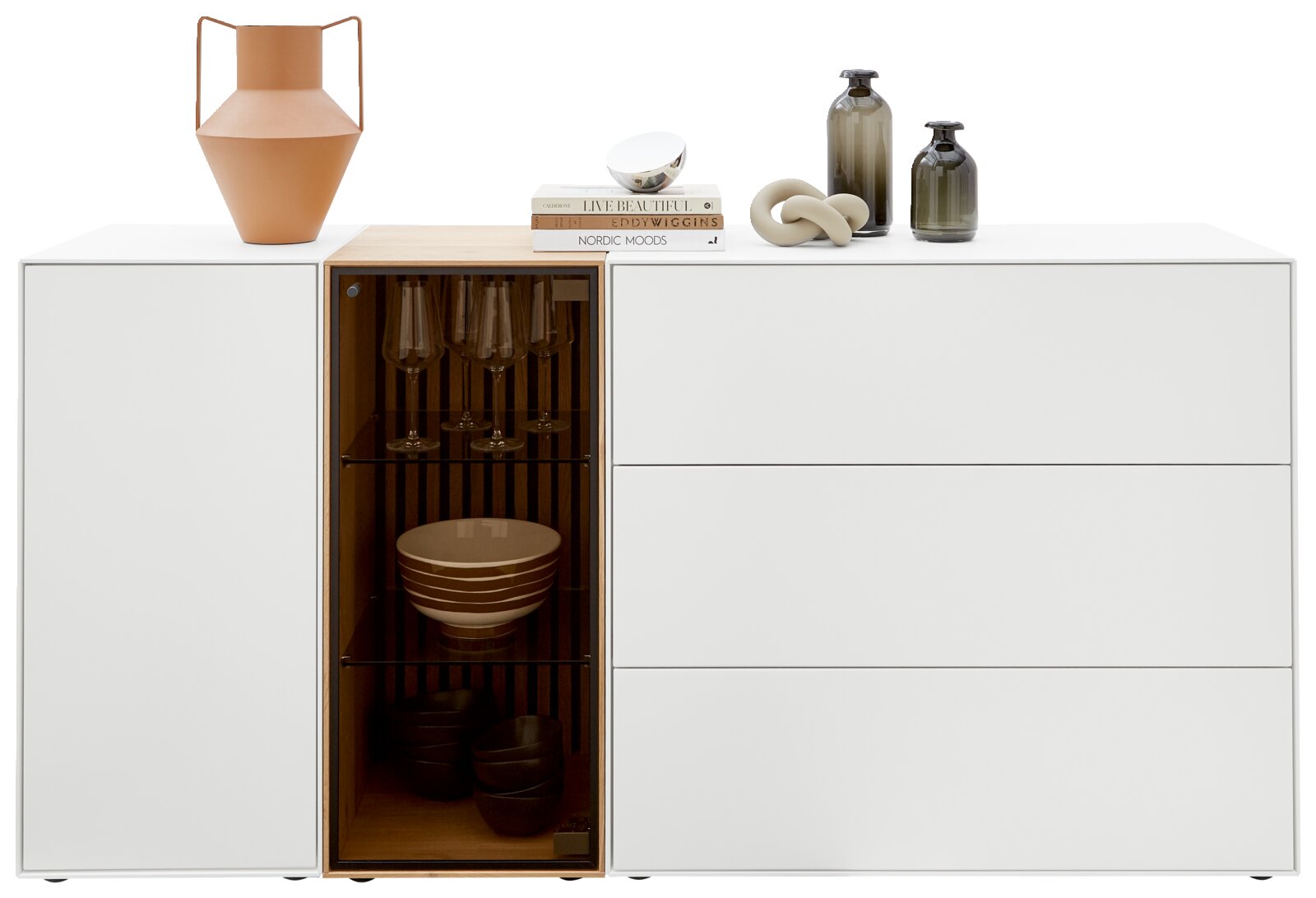 Modernes weißes Sideboard mit Glasvitrine, dekoriert mit Vasen und Büchern, Frontalansicht.