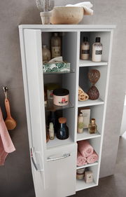 Moderner weißer Midischrank mit offenen und geschlossenen Fächern, gefüllt mit Pflegeprodukten und Handtüchern, aus der Vogelperspektive.