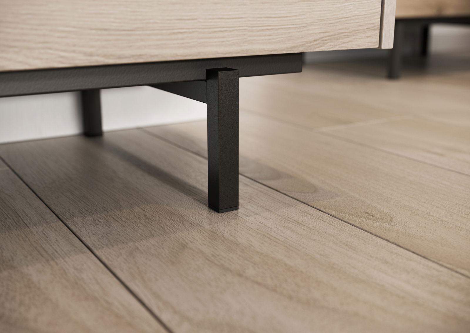 Nahaufnahme eines TV-Lowboards mit schwarzen Metallbeinen auf einem Holzfußboden, seitliche Perspektive