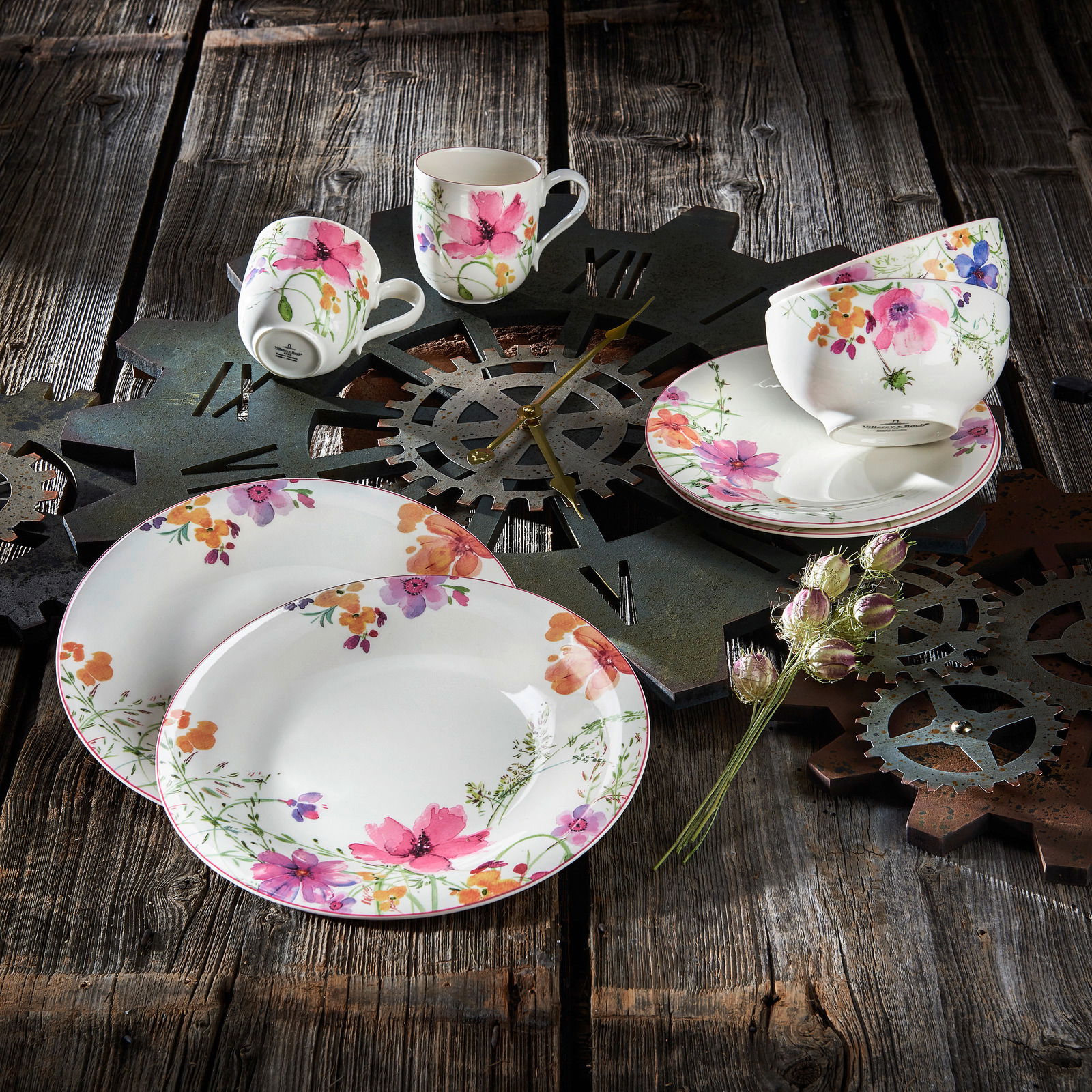 Vogelperspektive auf ein 8-teiliges Starter-Set Mariefleur mit floralem Design auf rustikalem Holztisch, bestehend aus Tellern, Tassen und Schalen.