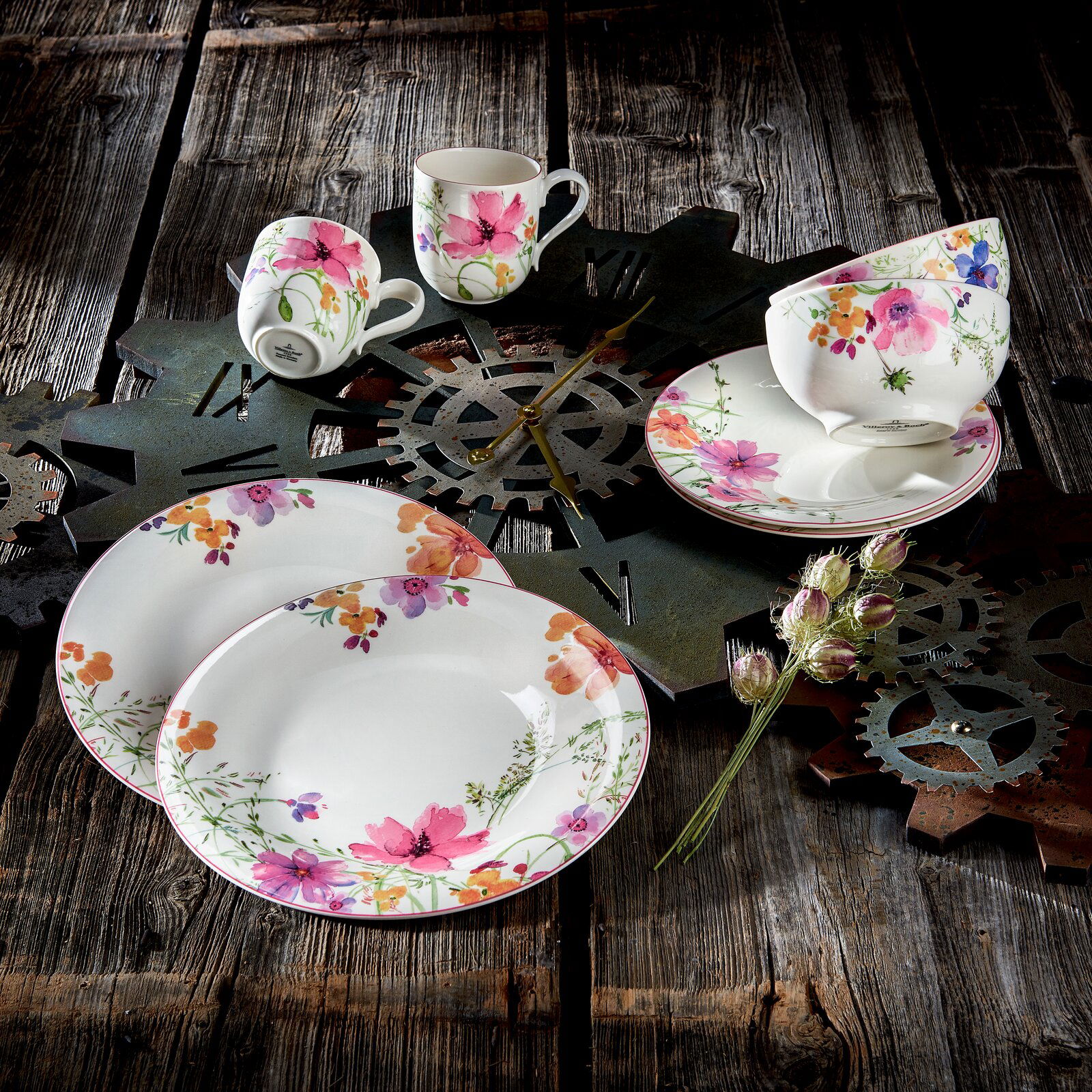 Vogelperspektive auf ein 8-teiliges Starter-Set Mariefleur mit floralem Design auf rustikalem Holztisch, bestehend aus Tellern, Tassen und Schalen.