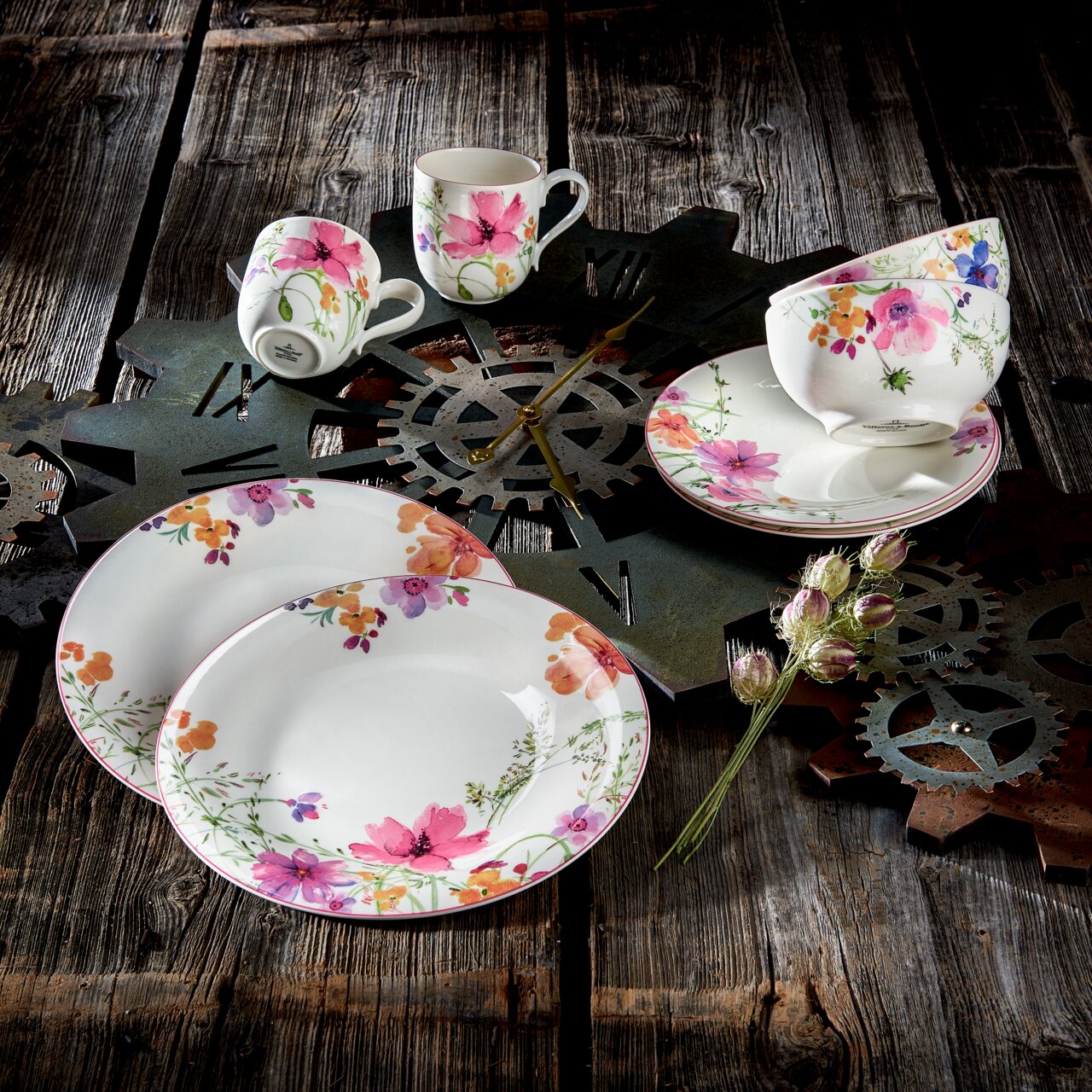 Vogelperspektive auf ein 8-teiliges Starter-Set Mariefleur mit floralem Design auf rustikalem Holztisch, bestehend aus Tellern, Tassen und Schalen.