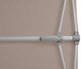 Nahaufnahme eines Sonnenschirms mit silbernem Gestänge und beigem Stoff, seitliche Perspektive.