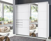 Moderner weißer Schwebetürenschrank mit Spiegel, frontale Ansicht in einem hellen Raum mit großen Fenstern.