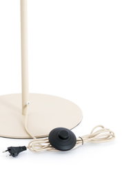Detailaanzicht van onderen van een crèmekleurige vloerlamp met ronde voet, textielsnoer, zwarte voetschakelaar en Europese stekker