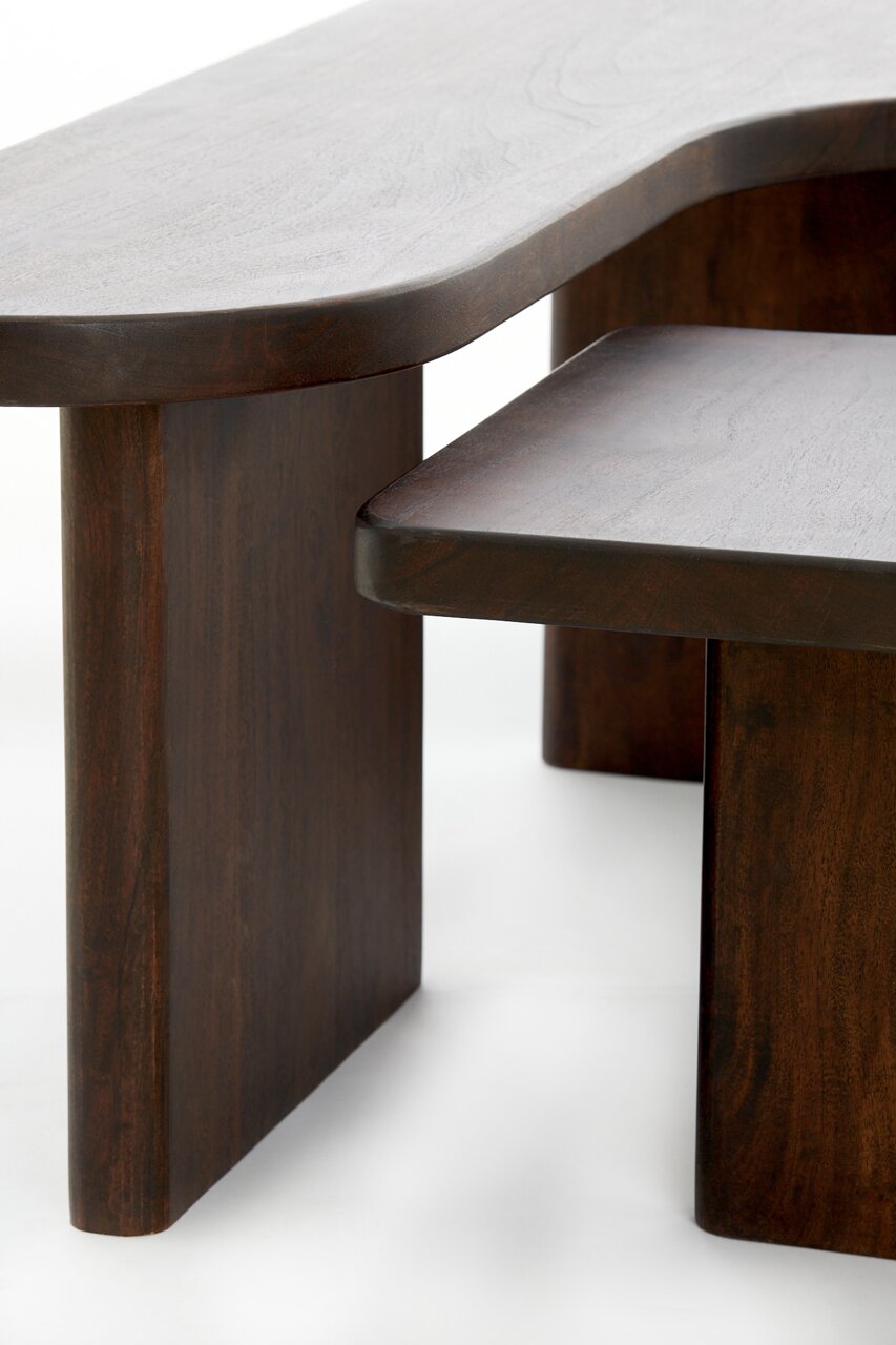 Nahaufnahme eines modernen Couchtisches aus dunklem Holz mit abgerundeten Kanten, seitliche Perspektive.