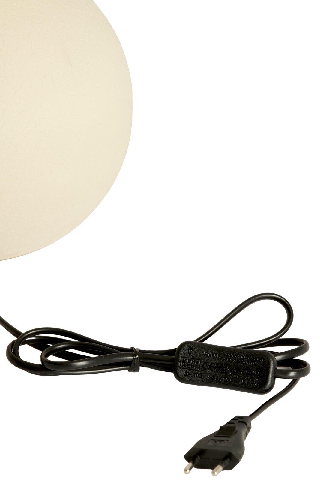 Nahaufnahme eines weißen Lampenfußes mit schwarzem Kabel und Stecker, seitliche Perspektive