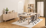 Modernes Sideboard aus hellem Holz mit vier Türen, dekoriert mit einer Pflanze, Kerzenhalter und Lampe, seitliche Perspektive.