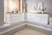 Zwei moderne, weiße Sideboards mit Holzoberfläche in einem hellen Raum, seitliche Perspektive.