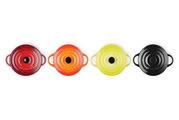 Vier Mini-Cocottes in verschiedenen Farben (Rot, Orange, Gelb, Schwarz) aus der Vogelperspektive.