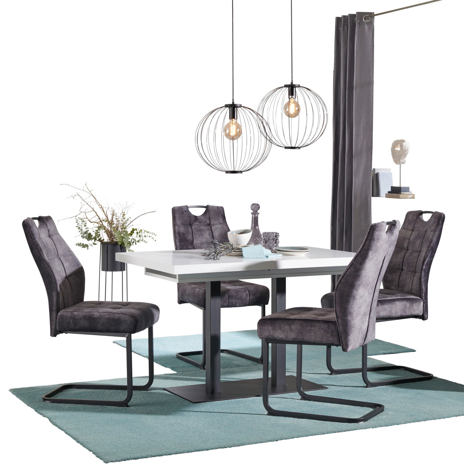 Moderner Esstisch mit vier grauen Stühlen, dekoriert mit Geschirr und Pflanzen, aus seitlicher Perspektive fotografiert.