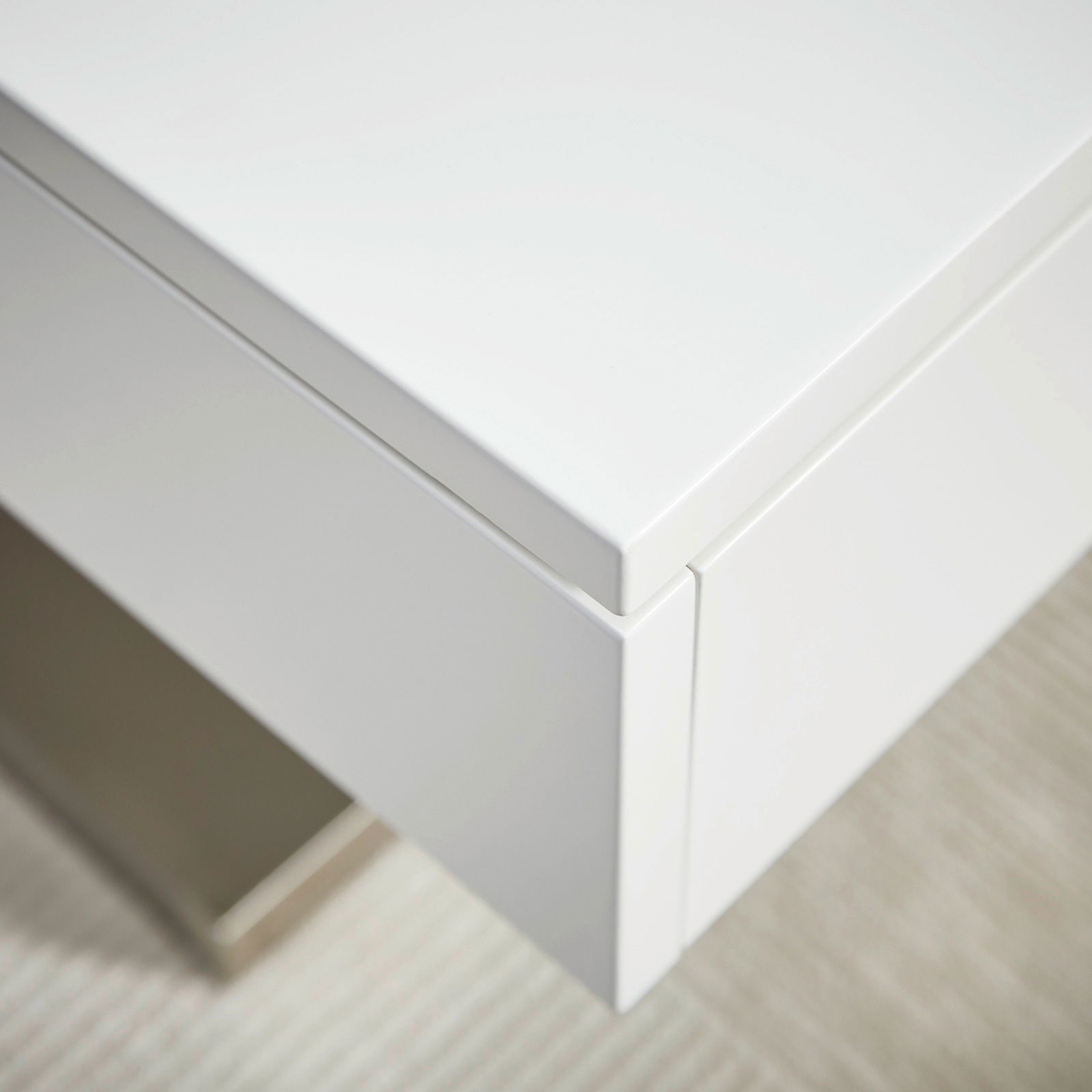 Nahaufnahme eines modernen weißen Couchtischs mit klaren Linien und minimalistischer Ästhetik, von oben betrachtet.