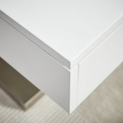 Nahaufnahme eines modernen weißen Couchtischs mit klaren Linien und minimalistischer Ästhetik, von oben betrachtet.