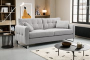 Hellgraues, modern gepolstertes 3-Sitzer-Sofa mit Steppnähten und Chromfüßen im Wohnzimmer, Frontansicht leicht schräg von links