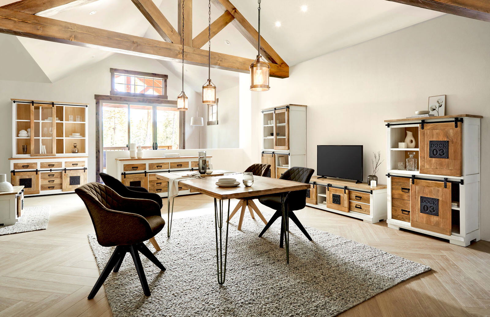Landscape Sideboard DOCK Wohnzimmer mit rustikalen Holzmöbeln, darunter Vitrine, Sideboard und Highboard, in einem hellen Raum mit Holzbalkendecke, aus der Perspektive von vorne betrachtet.