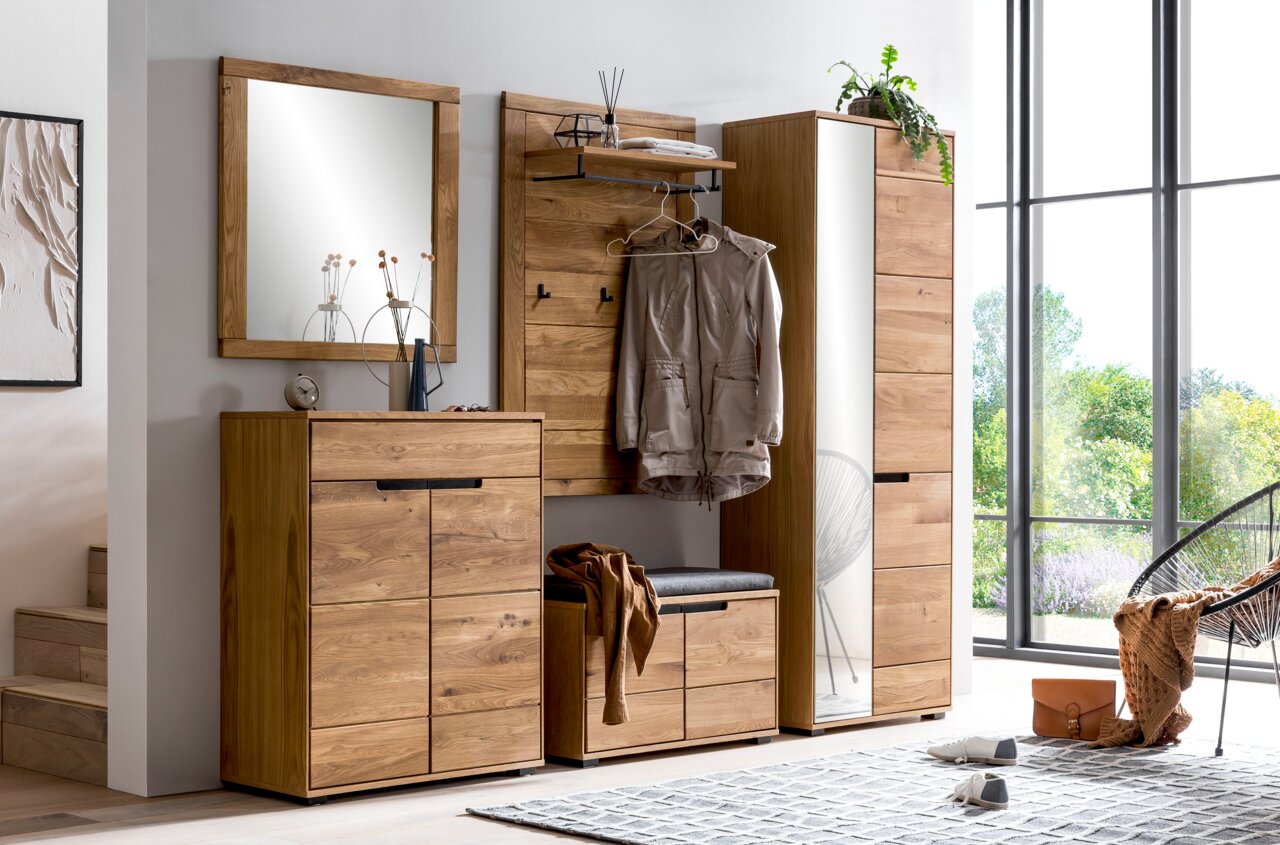 Moderne Garderobenkombination aus Holz mit Schuhschrank, Spiegel, Garderobenbank und Garderobenpaneel in einer hellen, einladenden Umgebung. Frontalansicht.