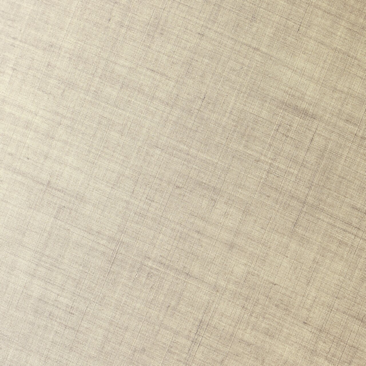 Nahaufnahme eines beigen Stoffes mit feiner Textur, schräg fotografiert.
