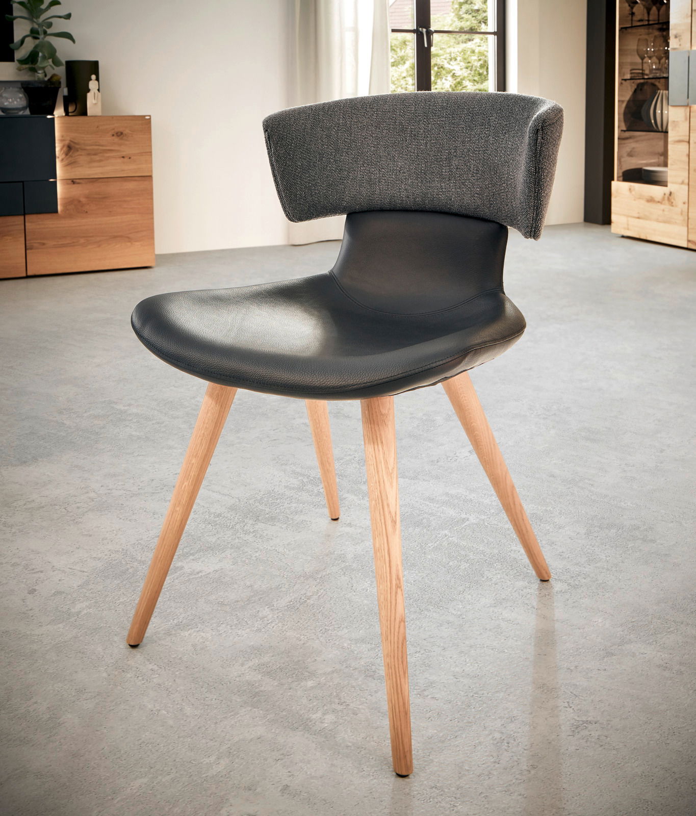 Moderner Stuhl mit schwarzem Sitz und grauer Rückenlehne, Holzbeine, seitliche Perspektive