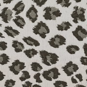 Nahaufnahme eines Stoffmusters mit Leopardenmuster in Schwarz und Grau auf beigem Hintergrund, Draufsicht.