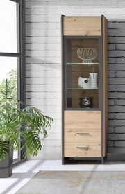 Moderne Vitrine aus Holz mit Glasfront, seitliche Perspektive, dekoriert mit Geschirr und Pflanzen im Hintergrund.