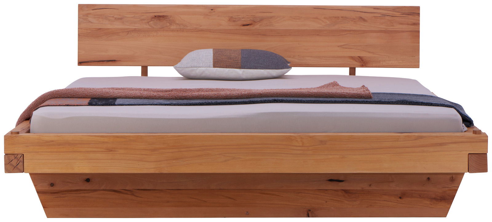 Frontale Ansicht eines Holzbettes mit Kopfteil, dekoriert mit einem Kissen und einer Decke.