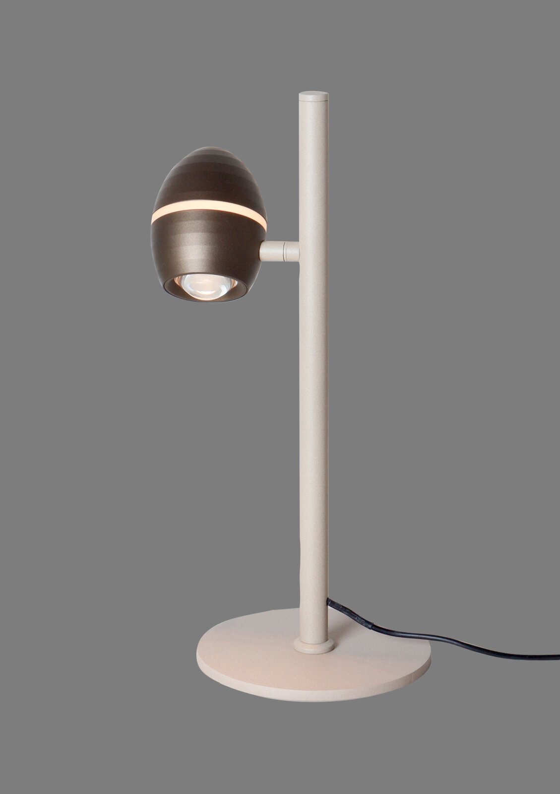 TRIO SELECT LED-tafellamp BEDFORD Moderne Tischlampe mit rundem Fuß und schlankem, hellem Stab; dunkler, eiförmiger Lampenkopf mit Lichtband, seitliche Ansicht in leicht schräger Perspektive vor grauem Hintergrund.