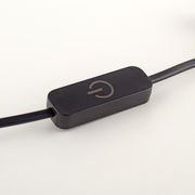 Nahaufnahme eines schwarzen Kabelschalters mit einem Ein-/Aussymbol, seitliche Perspektive.