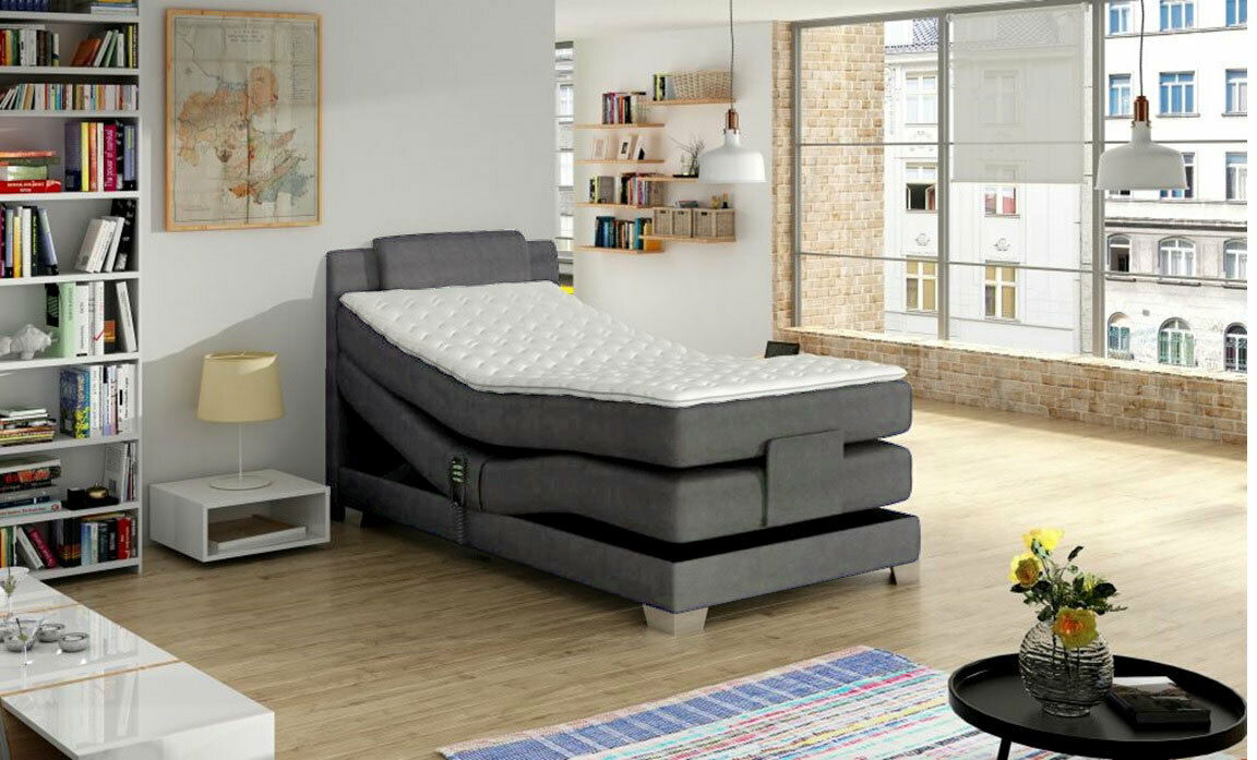 Modernes Boxspringbett in einem hellen, stilvollen Raum mit großen Fenstern, seitliche Perspektive.