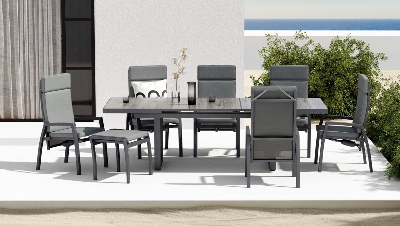 Moderner Gartensessel und Hocker in einer stilvollen Outdoor-Essgruppe, seitliche Perspektive