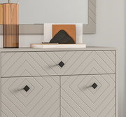 Nahaufnahme einer modernen Garderobenkombination mit geometrischem Muster und quadratischen Griffen, von vorne betrachtet.