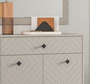 Nahaufnahme einer modernen Garderobenkombination mit geometrischem Muster und quadratischen Griffen, von vorne betrachtet.