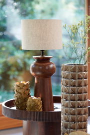 Lampenschirm 30-30-21 cm LIV auf einem Holztisch, umgeben von dekorativen Elementen, aus einer seitlichen Perspektive fotografiert.