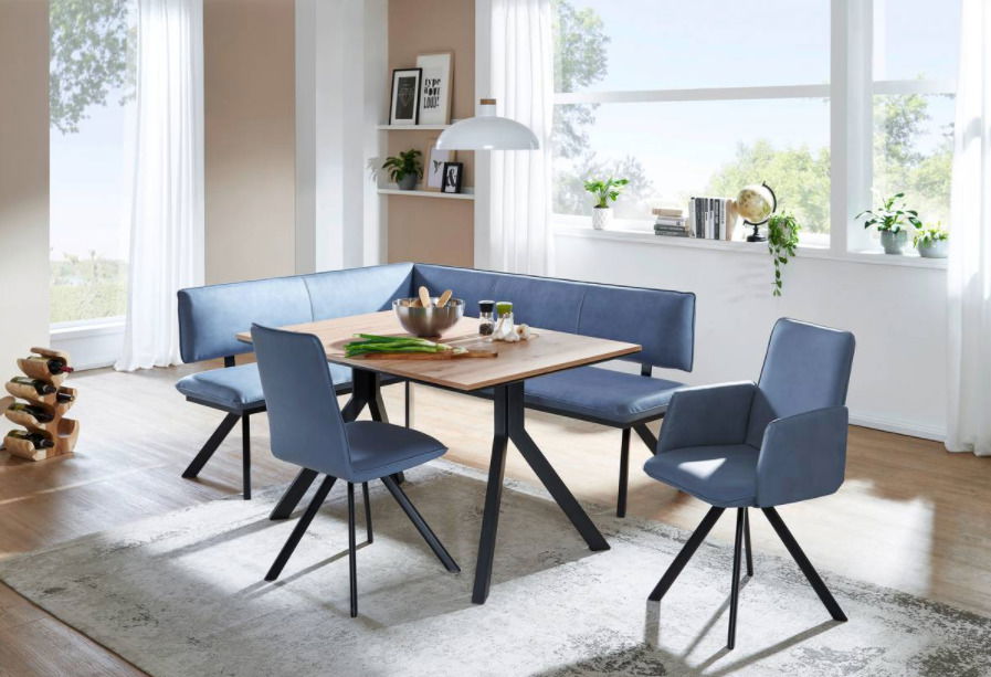 Moderne Esszimmer-Sitzgruppe mit blauer Eckbank und Stühlen, Tisch in Holzoptik, seitliche Perspektive