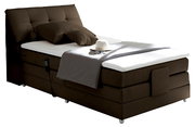 Boxspringbett in braunem Stoffbezug, seitliche Perspektive, mit Kopfteil, Kissen, Decke und Fernbedienung.