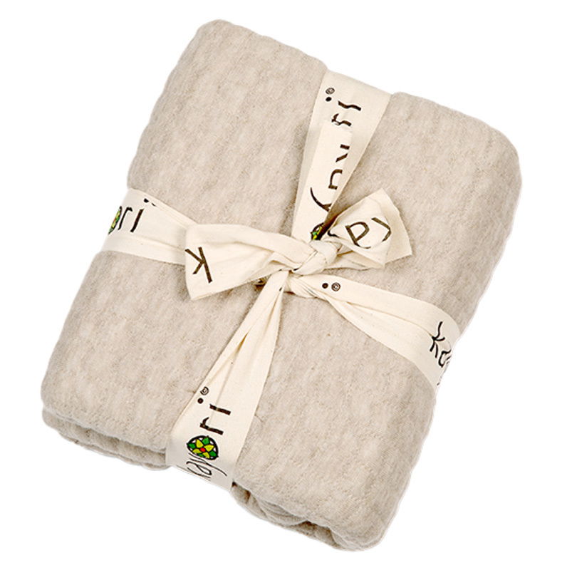 Beige gefaltetes Plaid 150x220cm, von oben fotografiert, mit dekorativem Band gebunden.