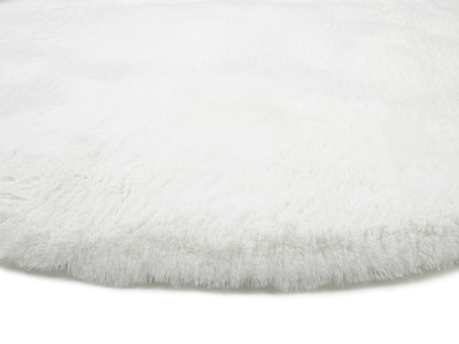 Nahaufnahme eines weißen, flauschigen Fellteppichs aus seitlicher Perspektive.