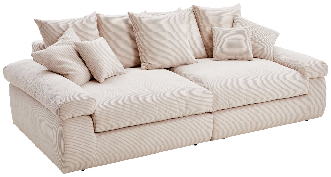 Großes, cremefarbenes Sofa mit mehreren Kissen, aus schräger Perspektive fotografiert.