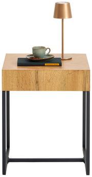 Beistelltisch aus Holz mit schwarzem Metallgestell, darauf eine Tasse, ein Buch und eine goldene Lampe, frontal betrachtet.