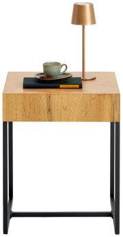 Beistelltisch aus Holz mit schwarzem Metallgestell, darauf eine Tasse, ein Buch und eine goldene Lampe, frontal betrachtet.