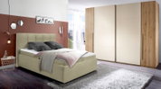 Modern gestoffeerd bed in een stijlvolle slaapkamer, zijaanzicht