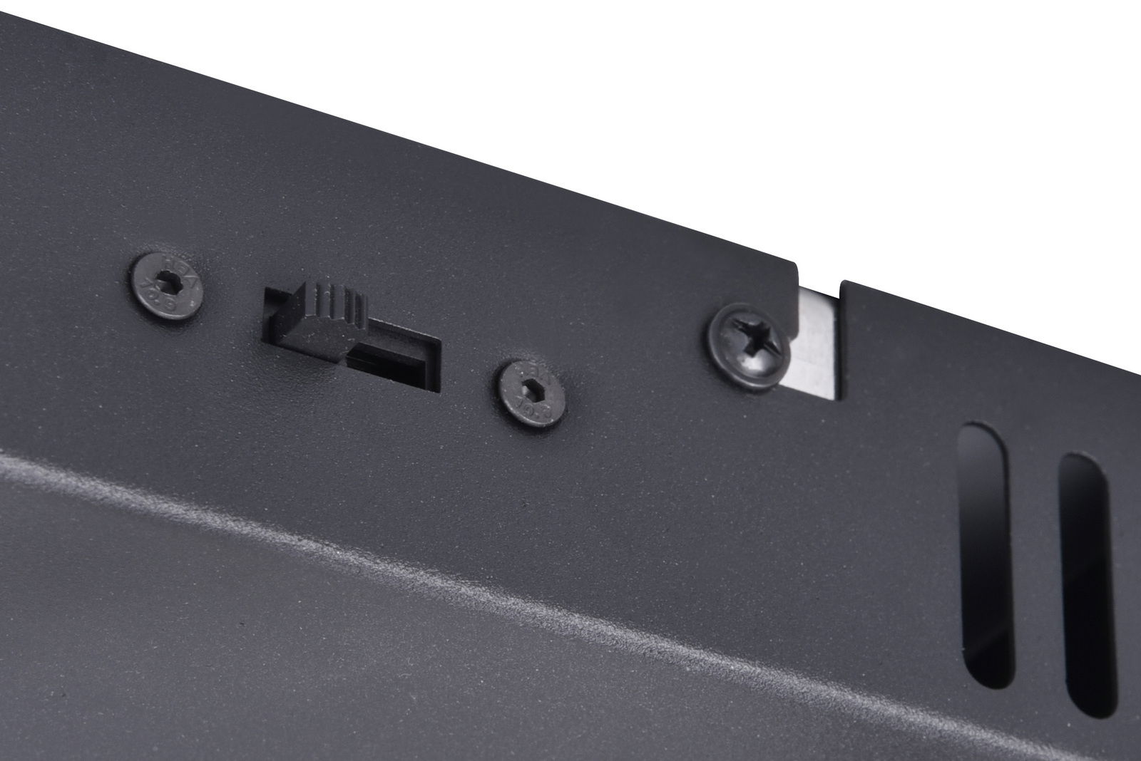 Nahaufnahme eines schwarzen LED-Gehäuses mit Schrauben und Schalter, seitliche Perspektive