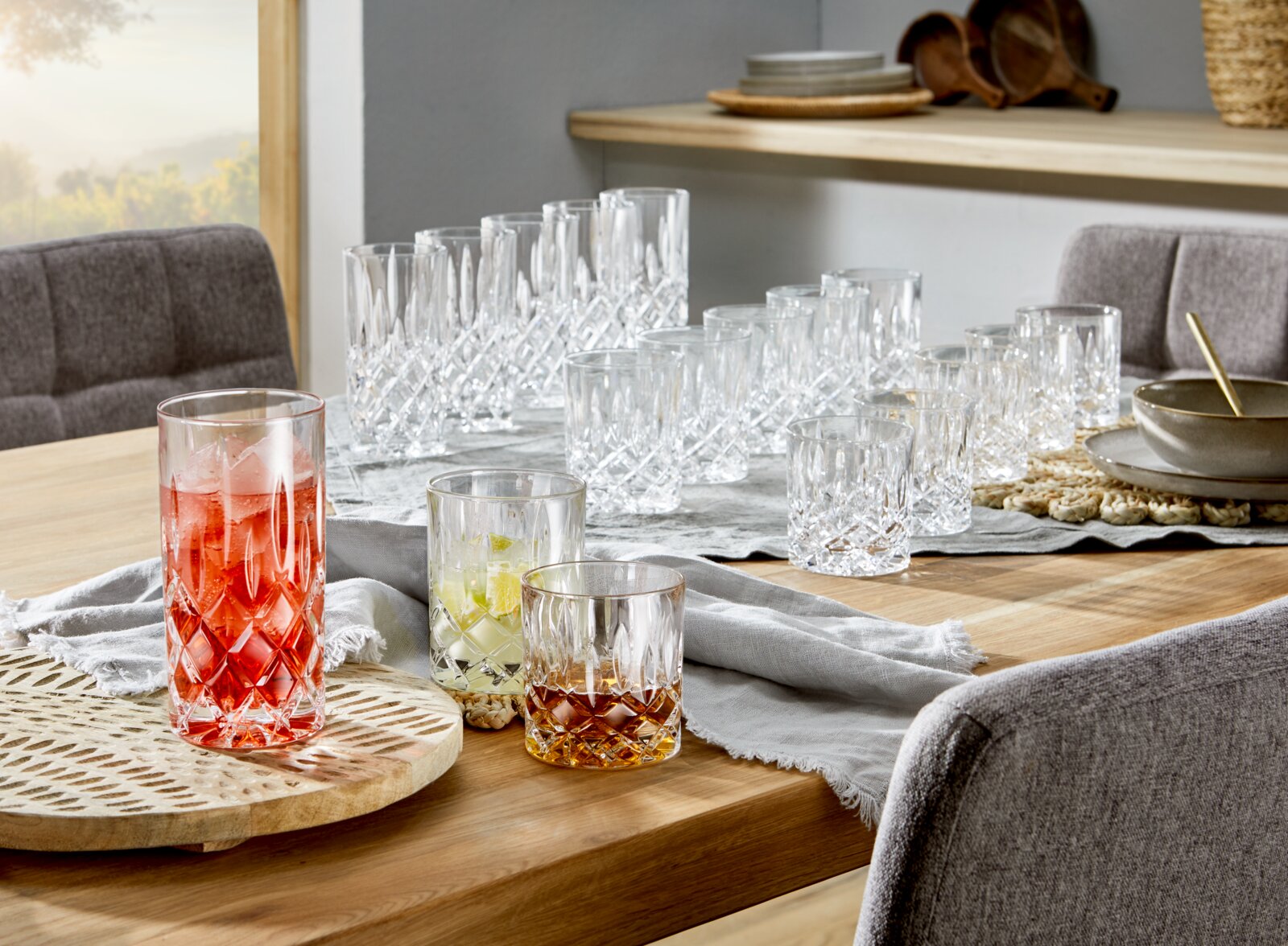 Een 18-delige Noblesse-glazenset op een tafel, bestaande uit verschillende kristallen glazen in een elegante tafeldecoratie. Aanzicht van schuin bovenaf.