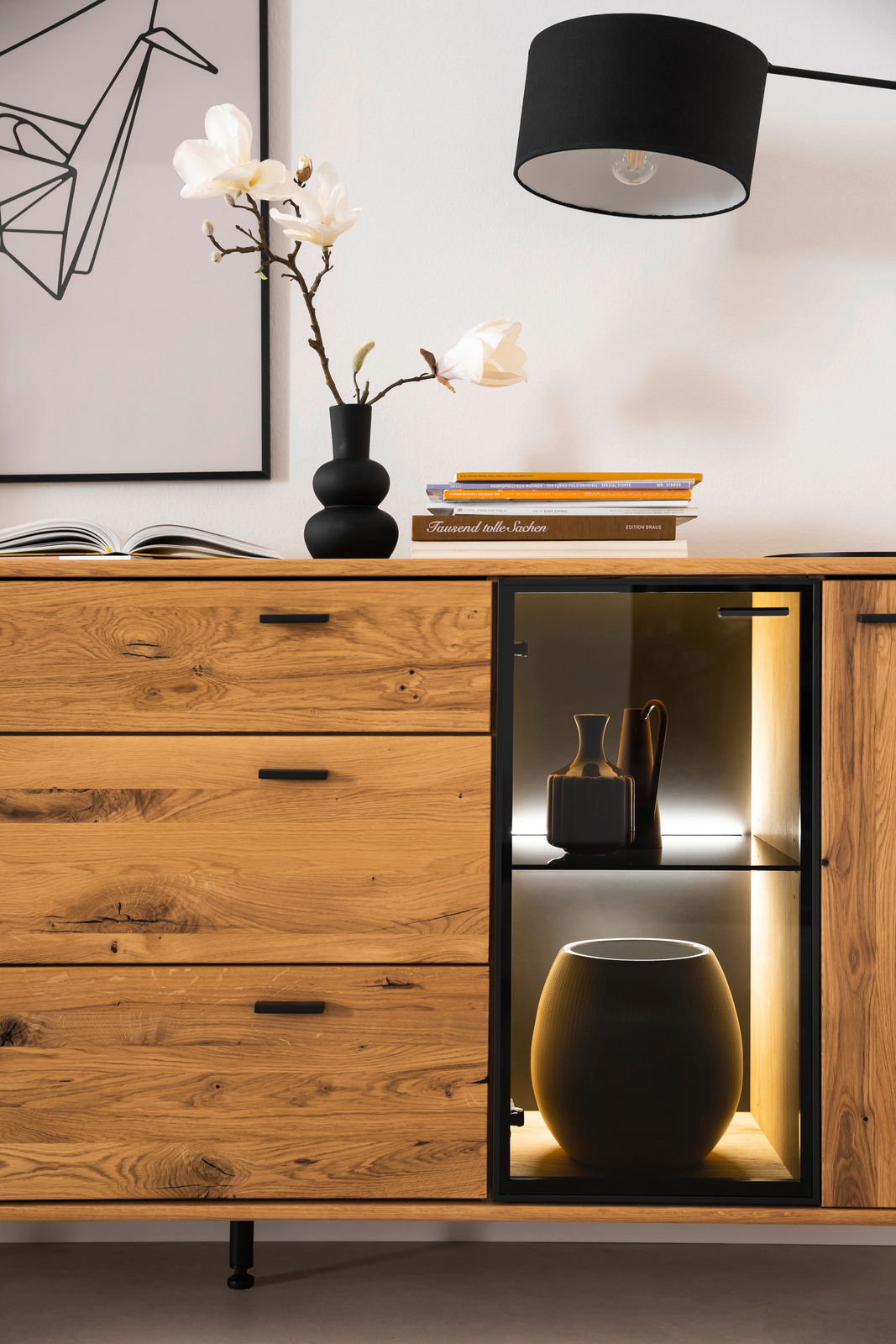 Modernes Sideboard aus Holz mit Schubladen und beleuchtetem Glaseinsatz, seitliche Perspektive