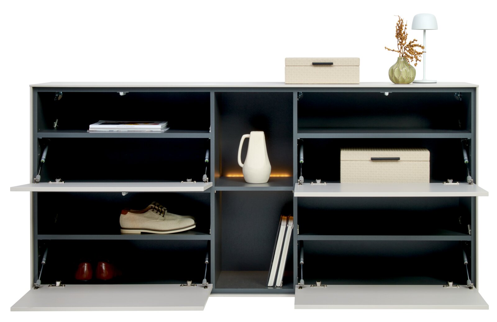 Modernes Sideboard/Schuhschrank in Weiß mit dunkelgrauen Fächern, drei nach unten öffnenden Klappen und offenen Regalen, dekoriert mit Boxen, Vase und Lampe; Frontalansicht.