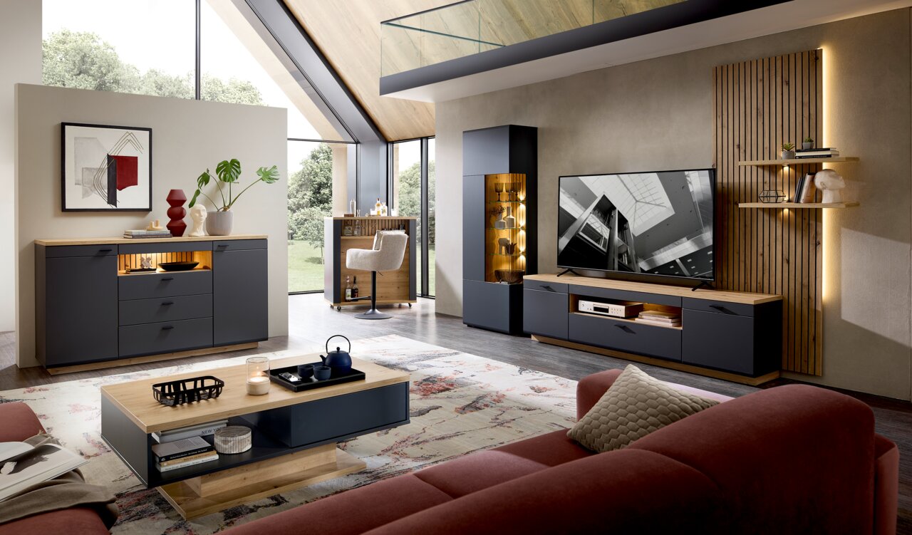 Moderne Wohnzimmer-Wandkombination in dunklem Holz und Grau, mit TV-Schrank, Vitrine und Regal, aus der Perspektive eines gemütlichen Wohnzimmers mit großen Fenstern.