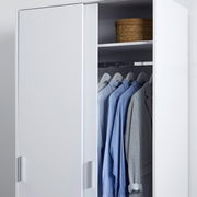Weißer zweitüriger Schiebetürenschrank XORA MIKA, teilweise geöffnet, mit Kleidung und Korb, seitliche Perspektive