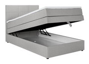 Graues Boxspringbett mit hochgeklappter Matratze und sichtbarem Stauraum, seitliche Perspektive