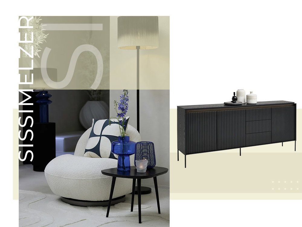 Een moderne woonkamer met een witte fauteuil, een staande lamp, blauwe vazen en een zwart dressoir.